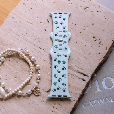 Yellow animal print Apple Watch band worn on wrist with bracelets
