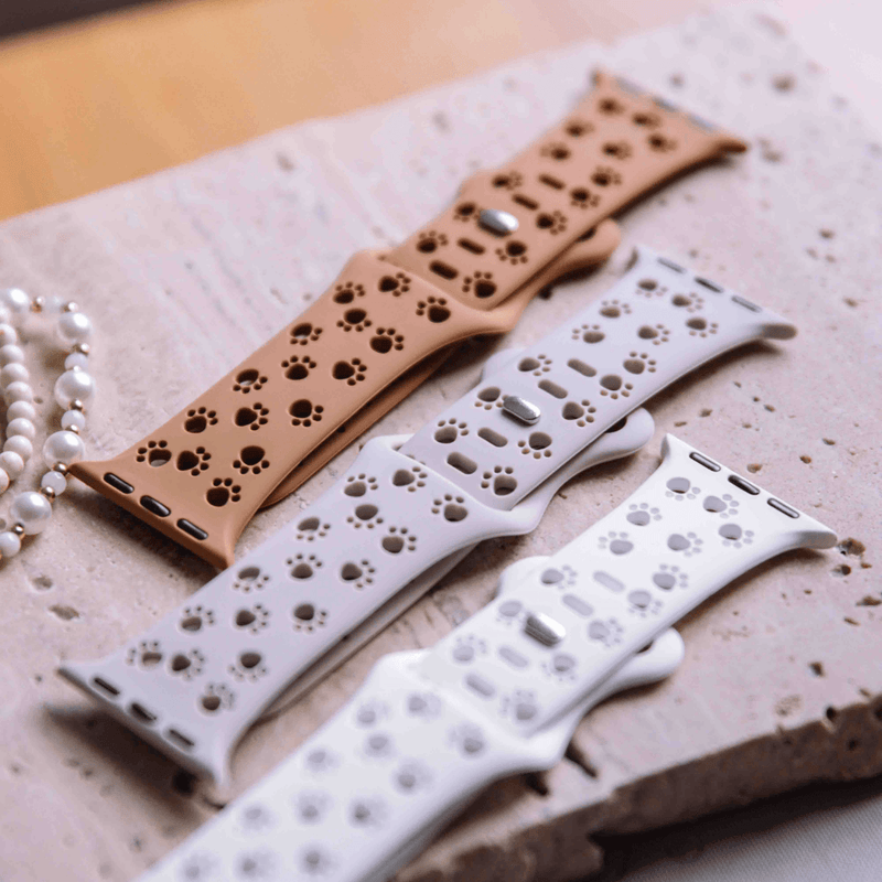 Pink animal print Apple Watch band on a display with jewelry
